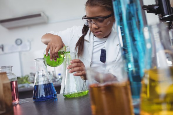 Student pouring liquid from one flask to another