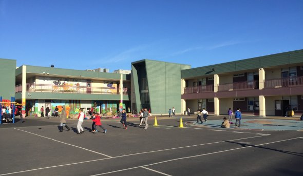 Students at recess in front of Monroe Elementary School building exterior