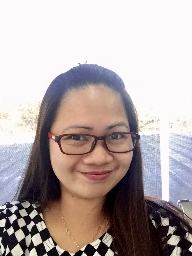 Grace Villanueva smiling in a checkered shirt