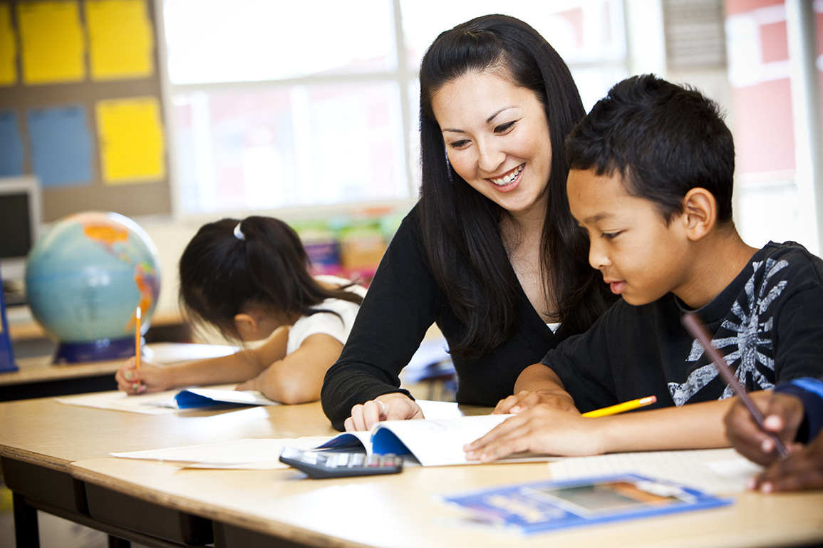 teacher with student learning at desk