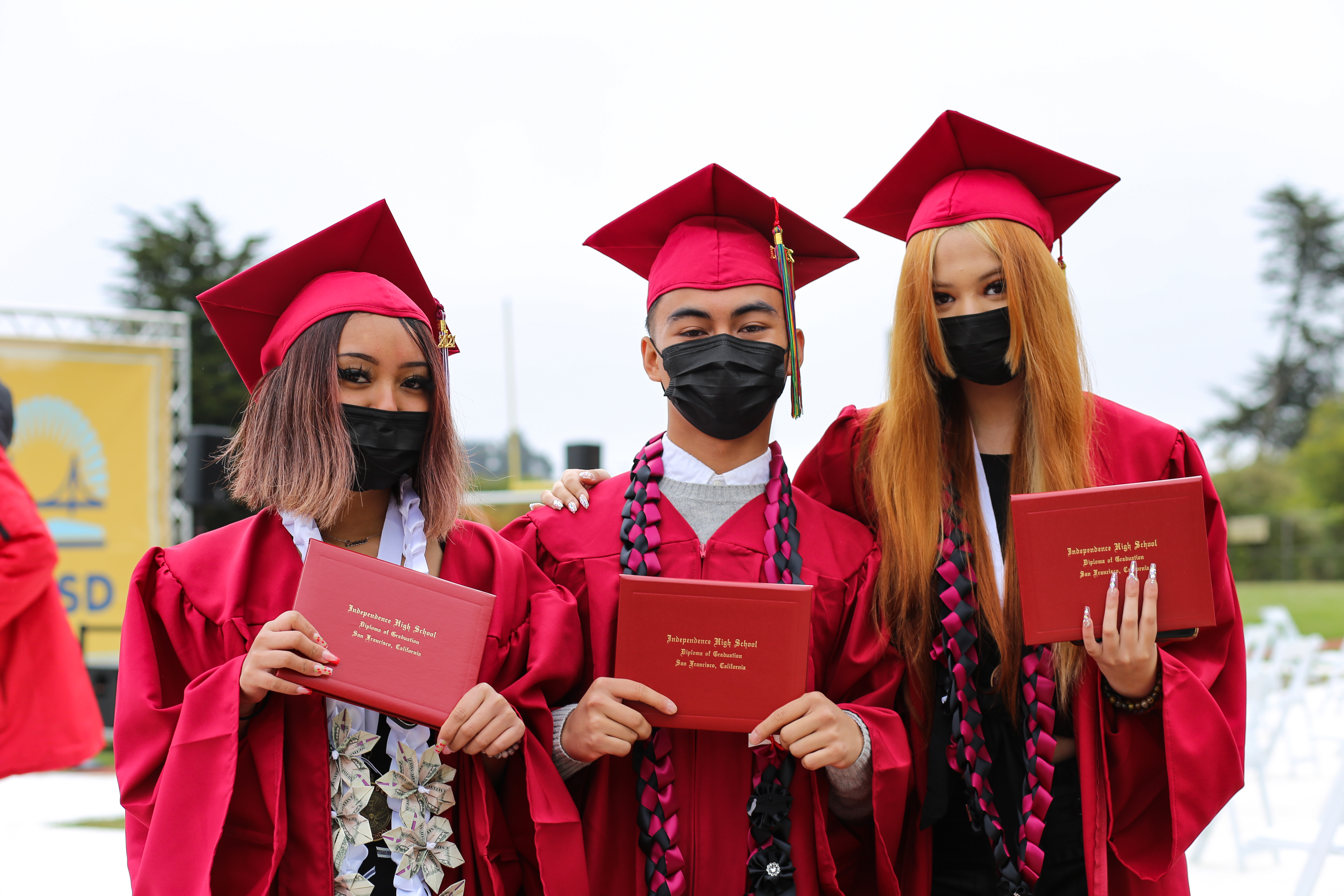 three students pose at the 2021 graduation ceremony