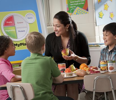 Teacher Eating Apple with Kids