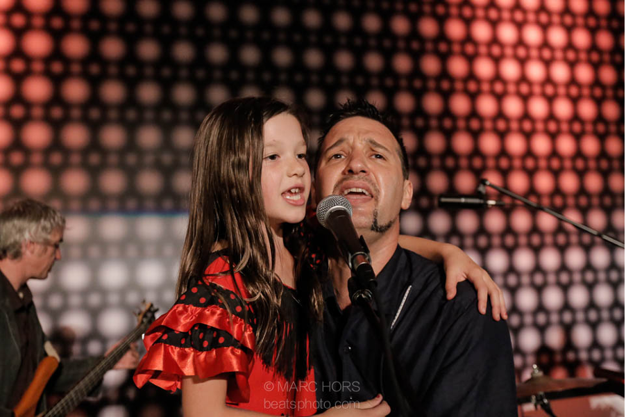 Music teacher Damina Nunez singing with his daughter who is wearing a red dress