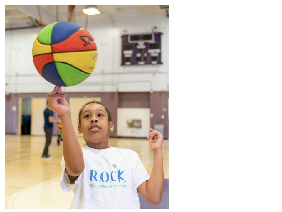 Child spinning basketball on fingertip