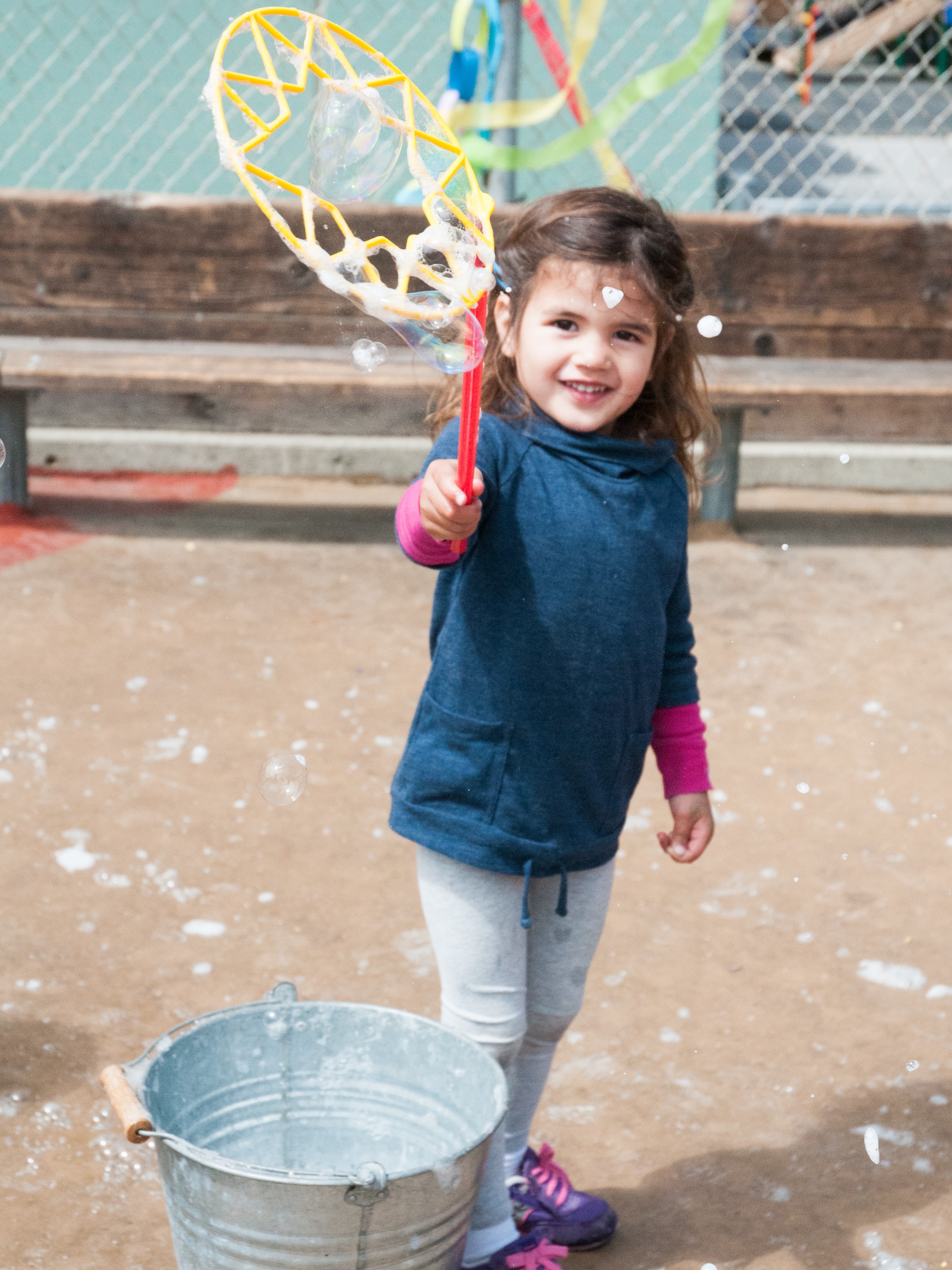 Girl making bubbles at an outdoor school festival