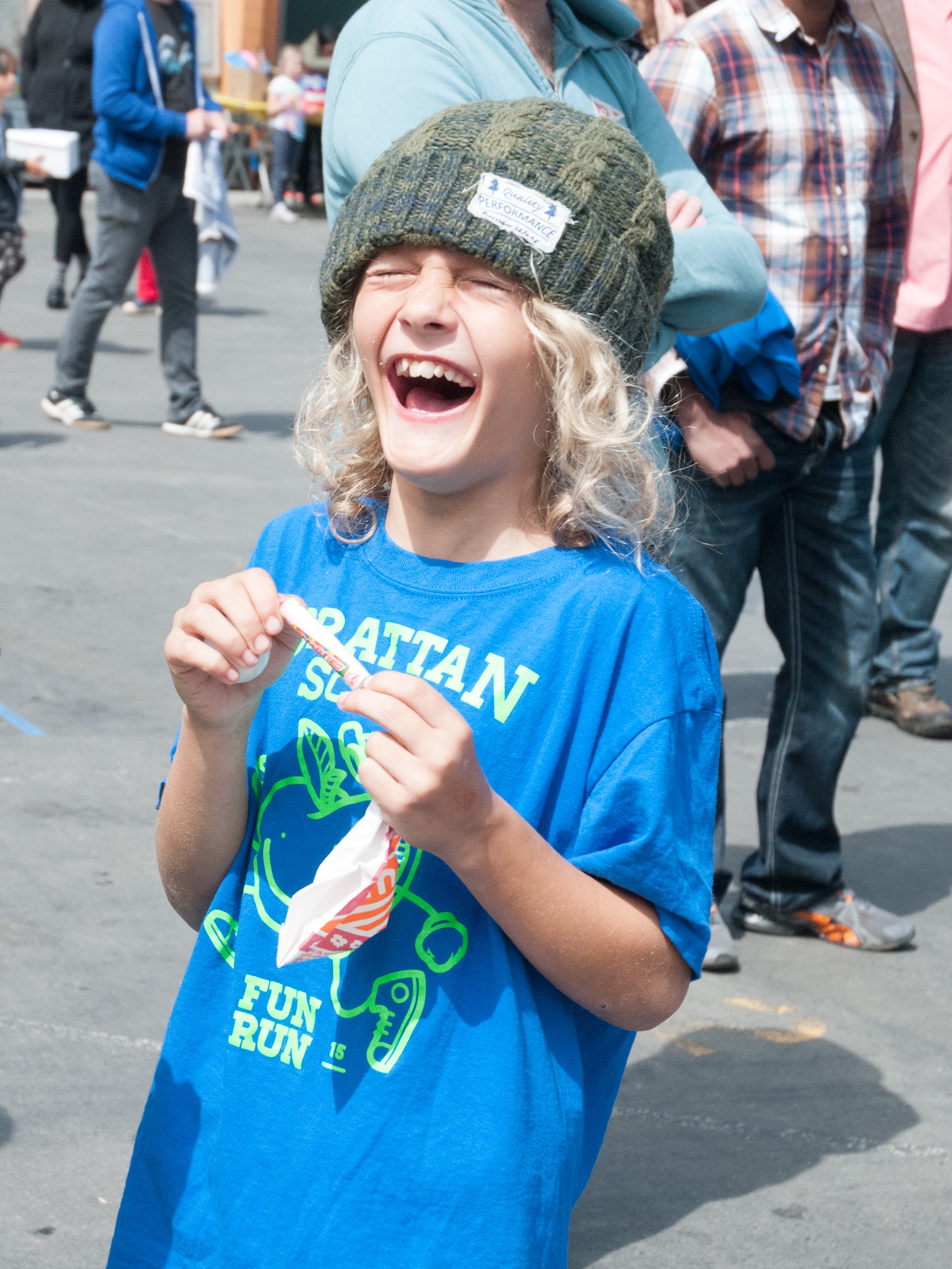 Child laughing wildly at an outdoor school festival