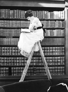 women sitting atop ladder whilst reading