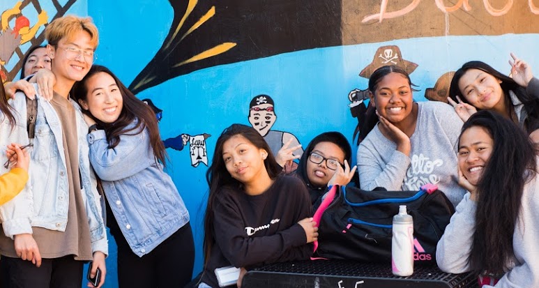 Students sitting around a table smiling