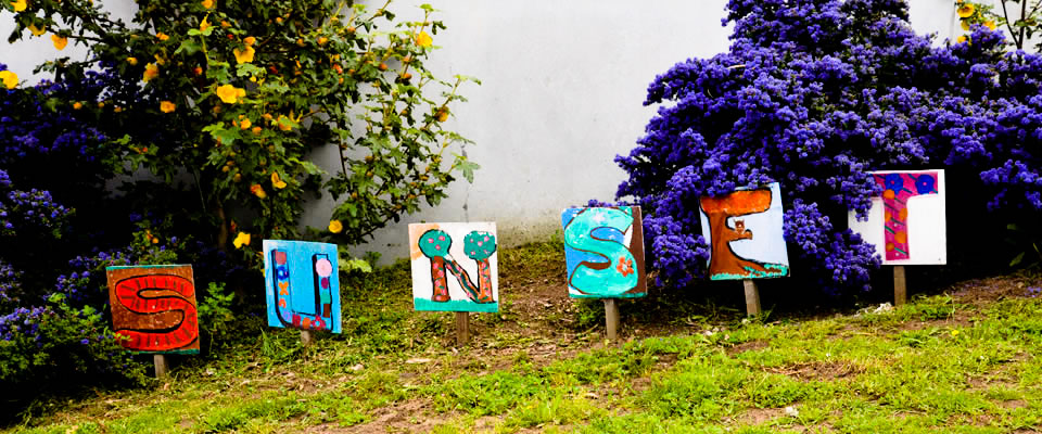 Small signs that spell S-U-N-S-E-T in front of flowering bushes