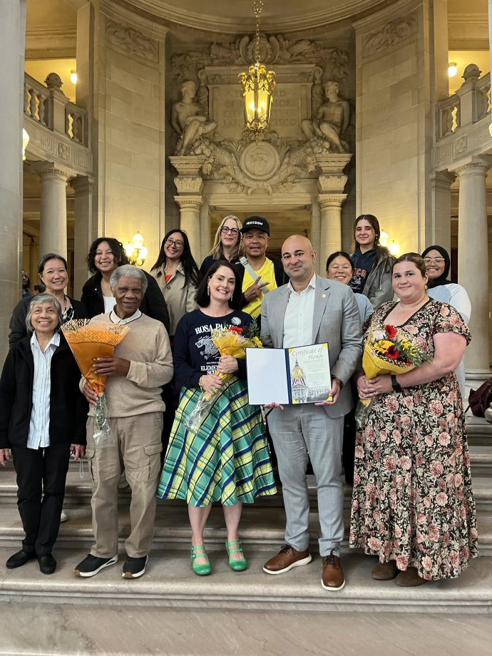 Group of staff from Rosa Parks and Raphael Weill at City Hall on the steps with Bilal Mahmood.  