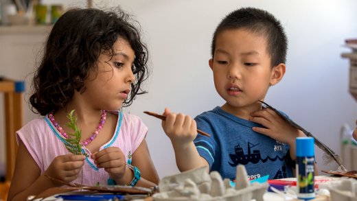 Two kindergarten students crafting and observing