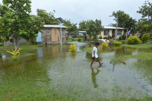 Young boy walking through a flooded village