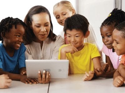 children engaged in digital learning with teacher