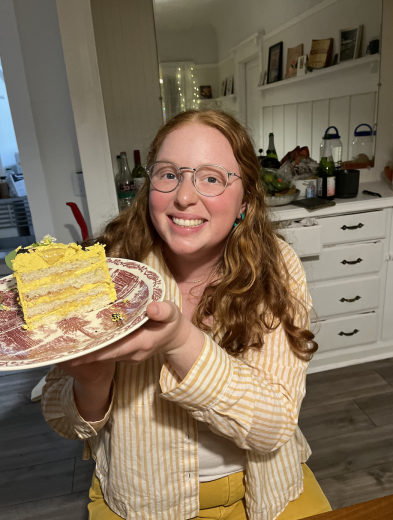 Redhead holding a slice of yellow cake 