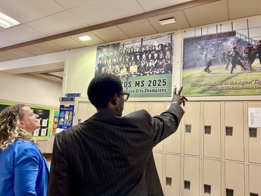 Aptos Principal pointing to sports posters