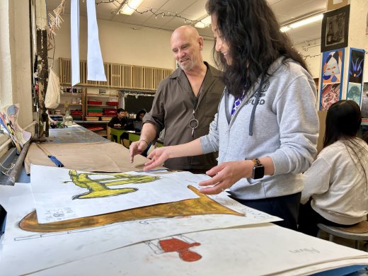 Superintendent Su looking at student artwork