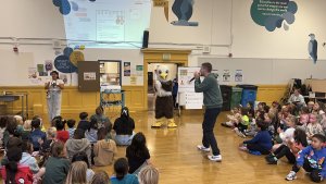 Students sititng in cafeteria listening to Mr. Woods