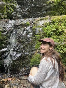 Lillie sitting on rocks by waterfall
