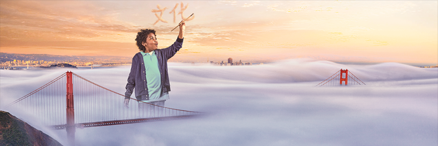 Boy painting Chinese characters in the air by the Golden Gate Bridge