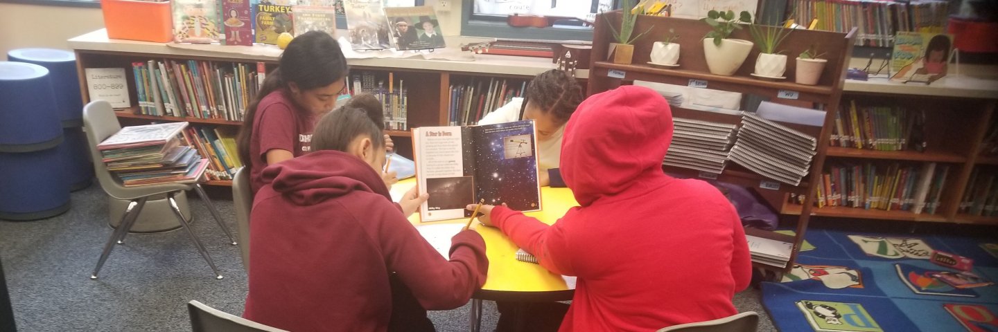 Students read books and write notes.