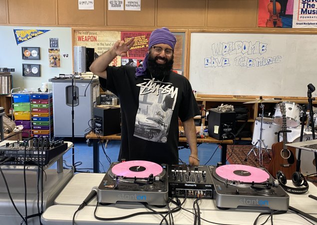 Mandeep Sethi, music teacher at June Jordan School for Equity posing with DJ turntables