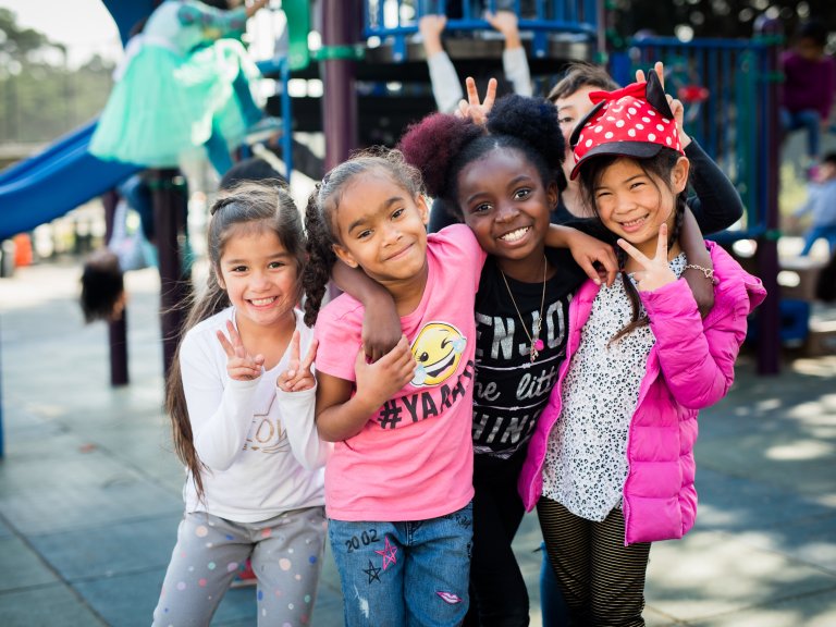 Four girls smiling on playground