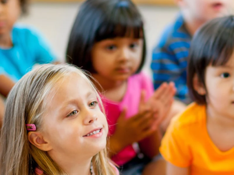 Students watching teacher read a story. 