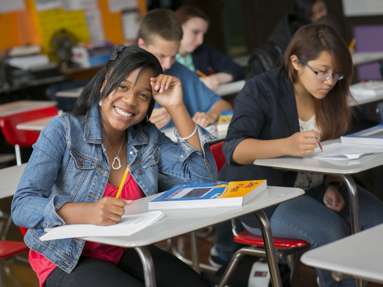 Girl Smiling at Camera while taking a test