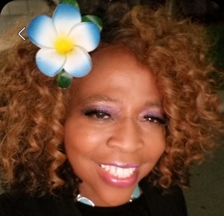 Ms. Brenda TK para with a blue flower in her hair