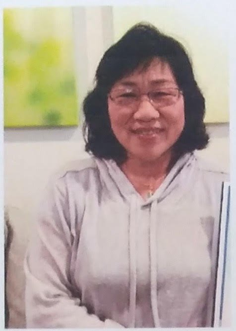 Ms. Sen smiling in a grey hooded sweatshirt
