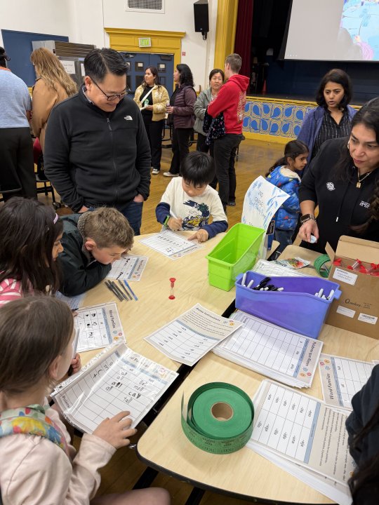 Students playing a word game at the table with Ms. Hernandez