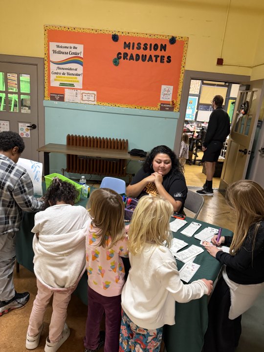 Ms. Zoila watchign students color their bookmarks