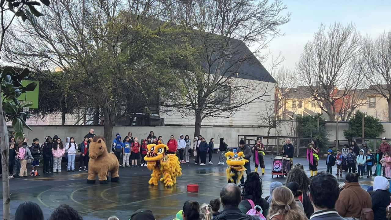 Dragon dancing in the yard with students watching