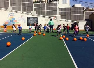 Elementary school students playing ball outdoors