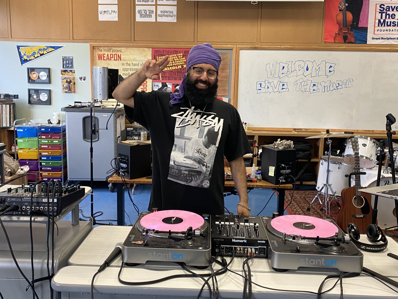 Mandeep Sethi, music teacher at June Jordan School for Equity posing with DJ turntables