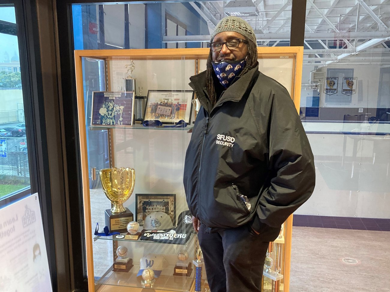 Gary W. Johnson, Athletic Director at Wallenberg High School stands in front of trophy case at school