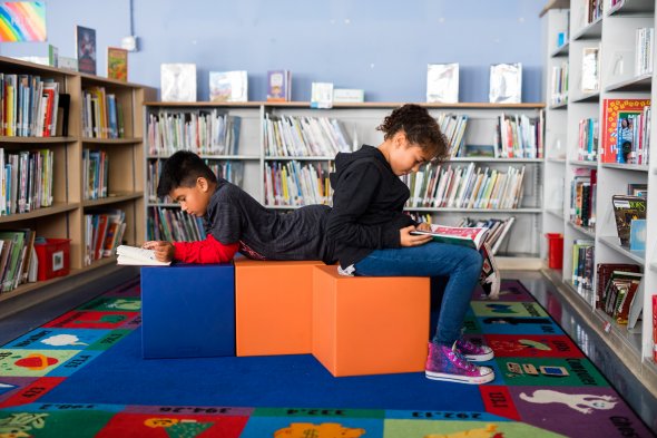 Two elementary school students reading in library