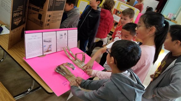 Children interacting with science fair display