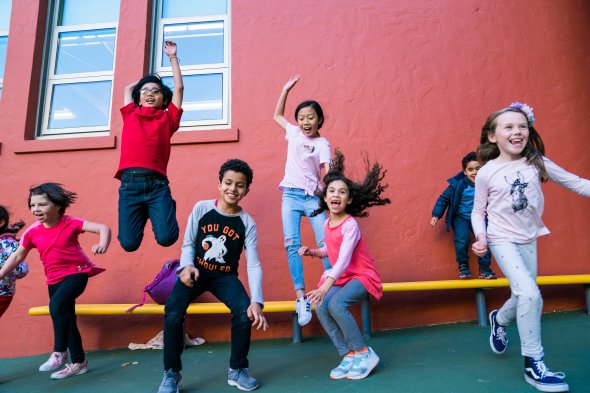 A row of elementary students jumping