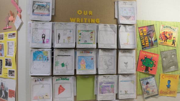 collection of student writing projects on wall