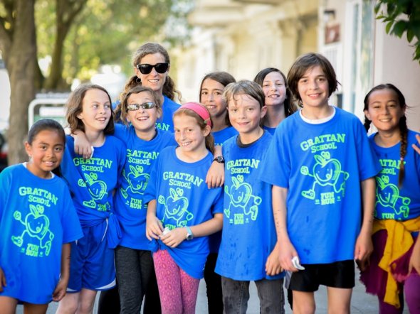 Children wearing matching t-shirts at an outdoor school fitness event