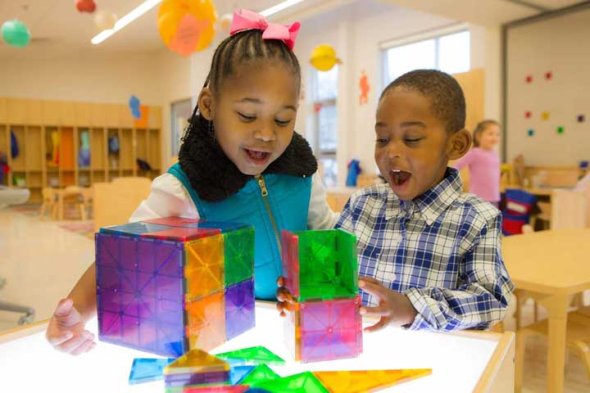 Two kindergarten students building with magnatiles