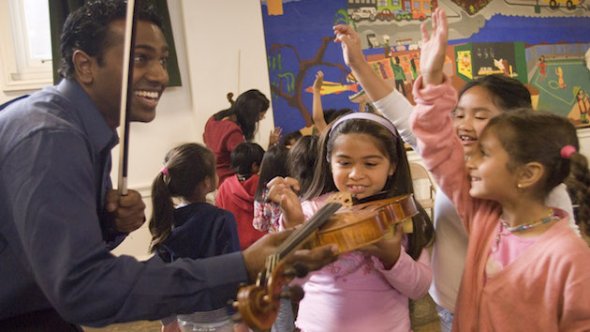 Students trying out playing violin