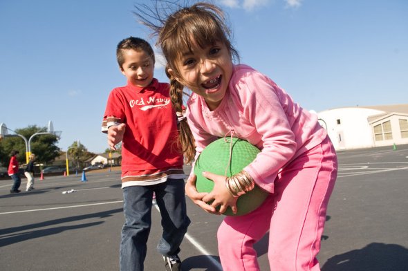 Two smiling kindergarteners playing catch