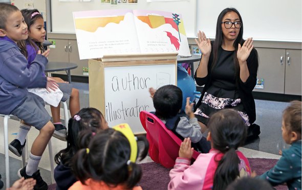Teacher with group of students on carpet learning about author and illustrator