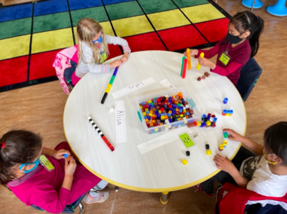 students exploring math materials at a table