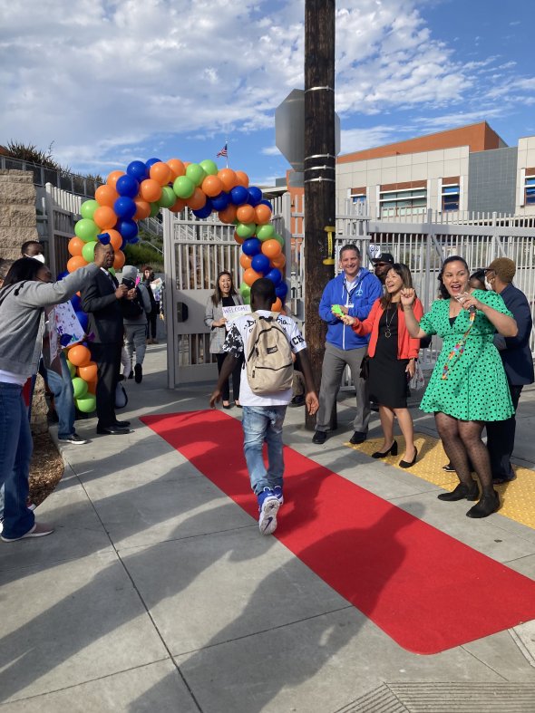 Staff welcoming students back to school with red carpet