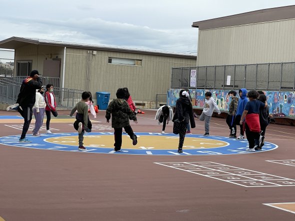 4th grade students arranged in a circle engaged in a stretching activity