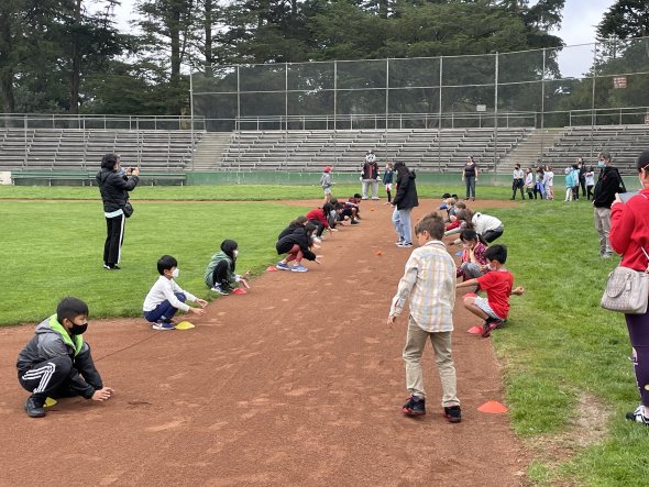 Students engaged in throwing and catching drills on a baseball field