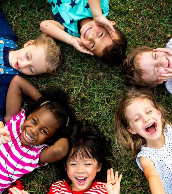 students laying on the grass in a circle